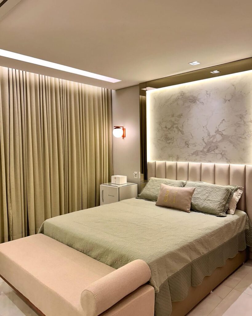 Quarto de casal com cabeceira modular estofada, papel de parede e iluminação em led