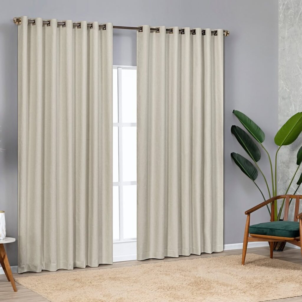 Ambiente com poltrona de madeira e assento estofado verde, vaso com planta e cortina blackout branca