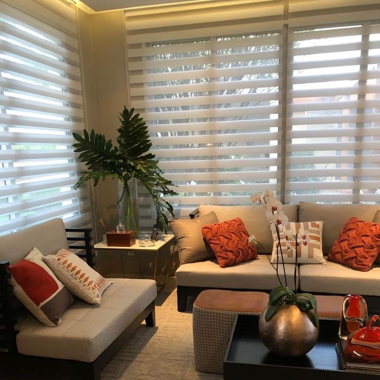 Sala de estar com sofás de linhas retas e almofadas em tons terrosos