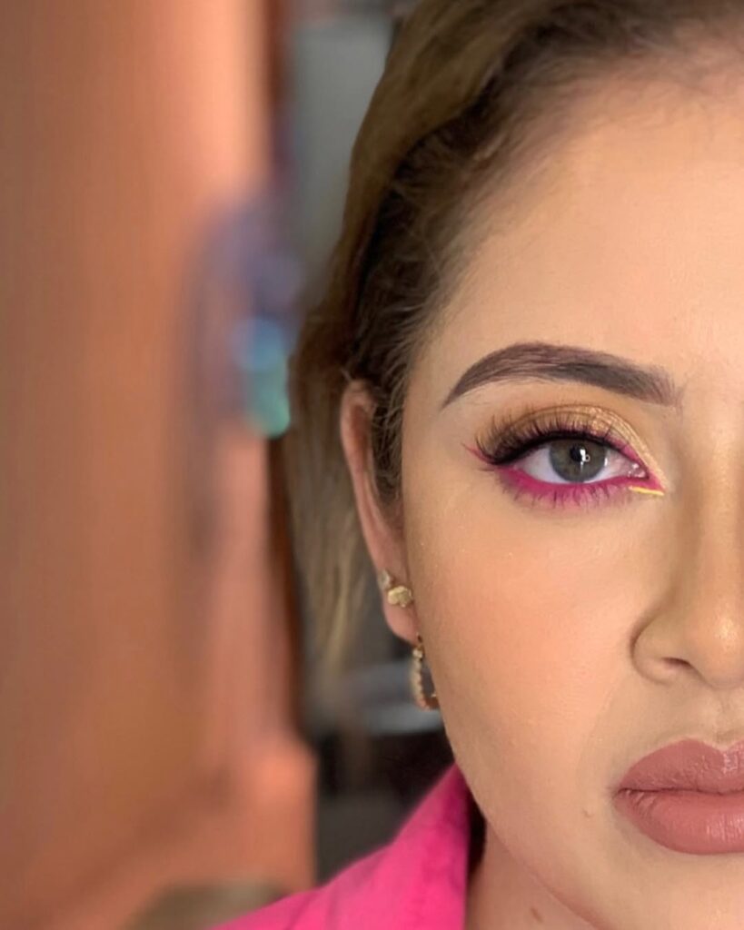Mulher de pele clara, com cabelo castanho e maquiagem com delineado inverno rosa