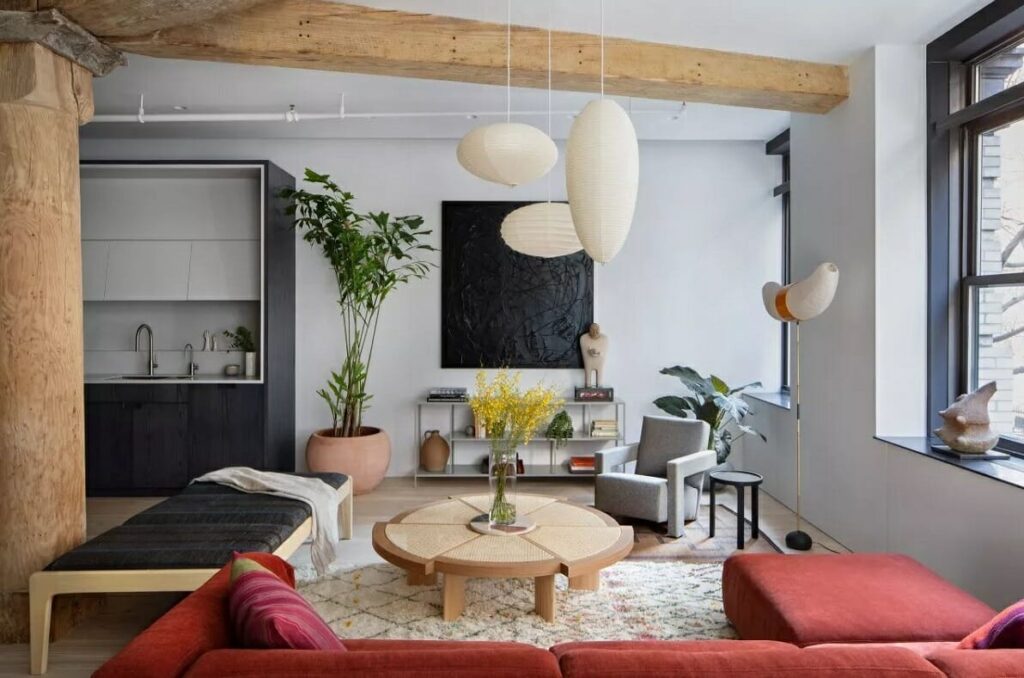 Sala de estar com sofá vermelho, mesa de centro em madeira com design diferenciado e pendentes