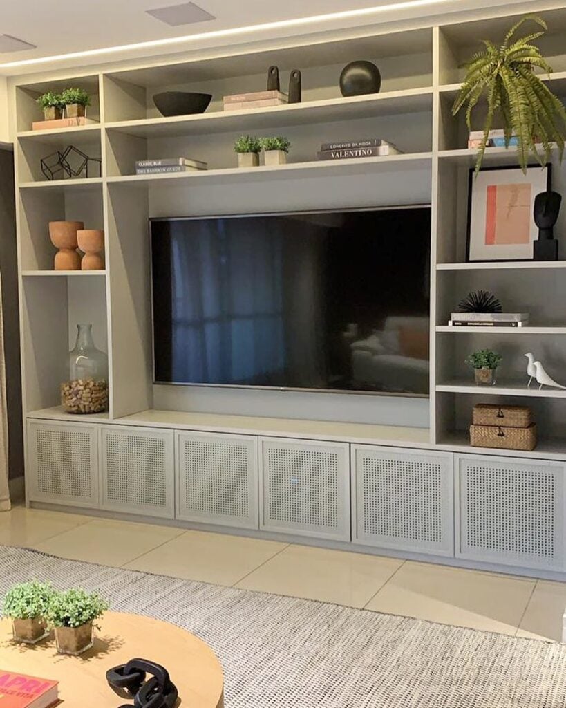 Sala de estar com estante cinza e portas de telinha