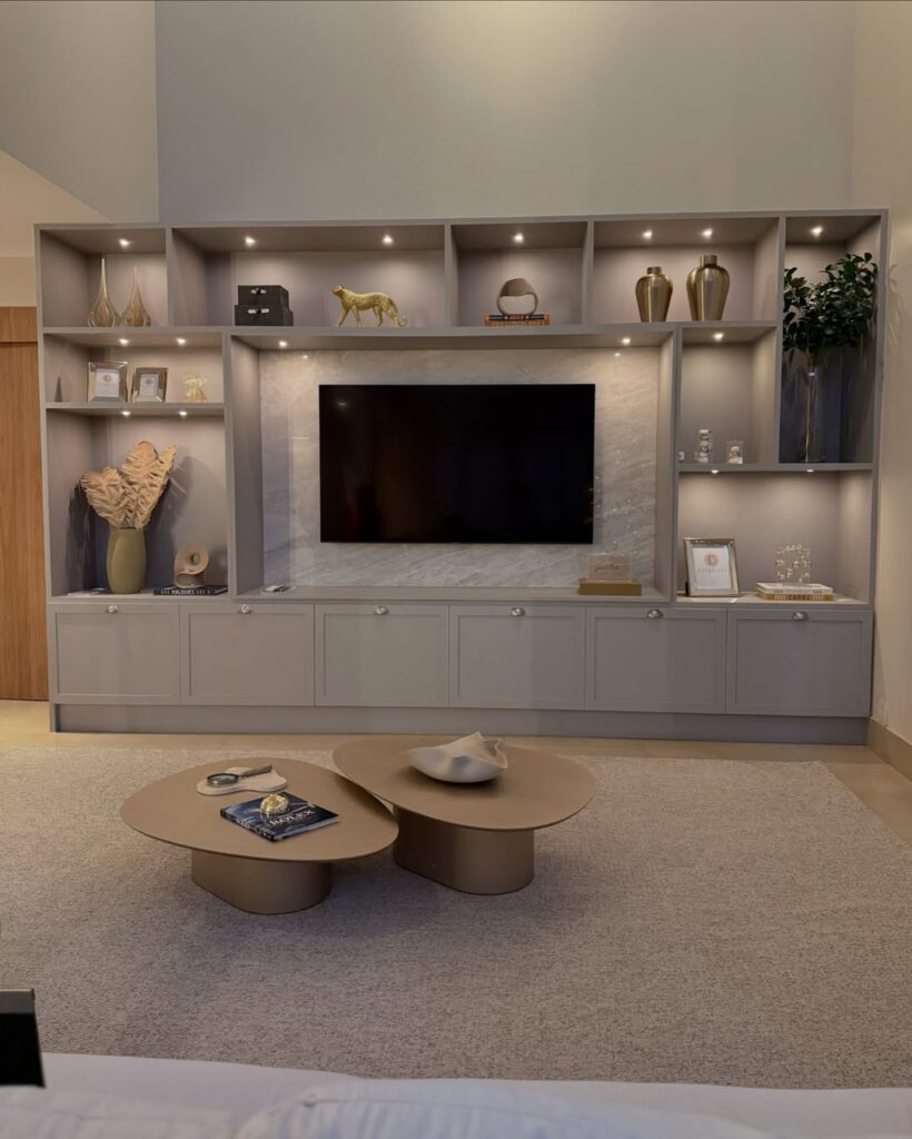 Sala de estar com grande estante cinza e objetos decorativos