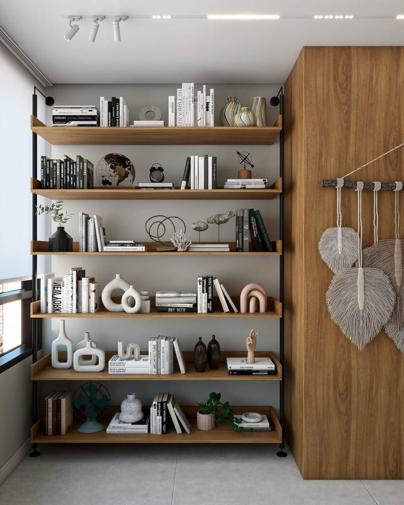 Estante de madeira com laterais de metal preto com livros e objetos decorativos