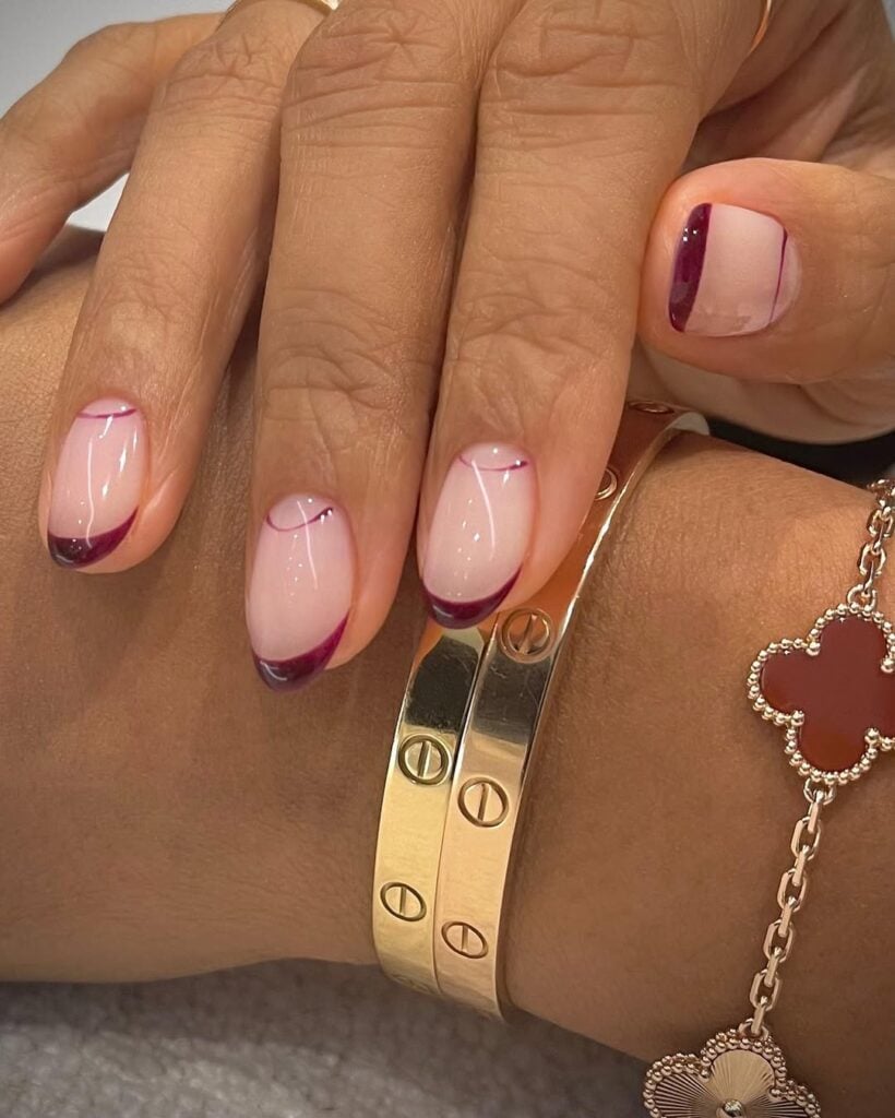 Mãos de pele "média", com unha amendoada com francesinha burgundy