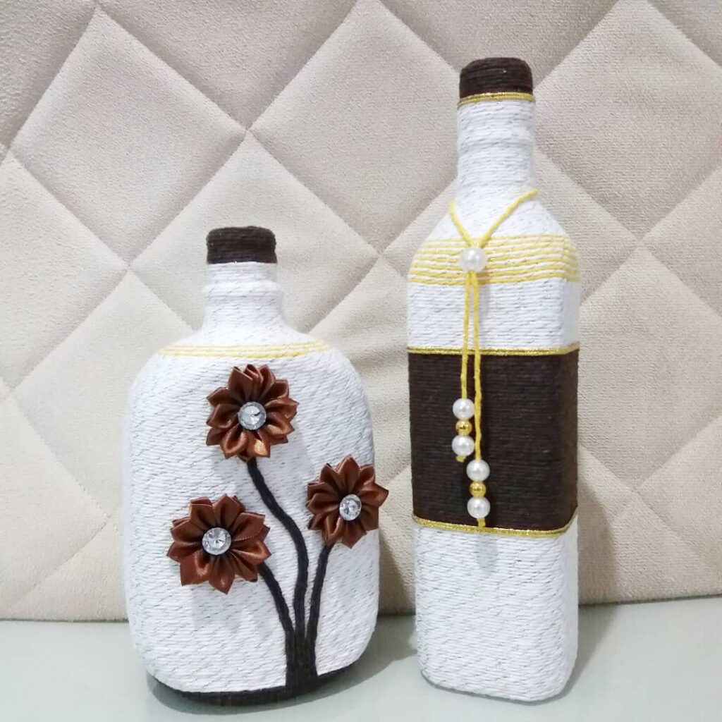 Garrafas decoradas com barbantes, flores e pérolas