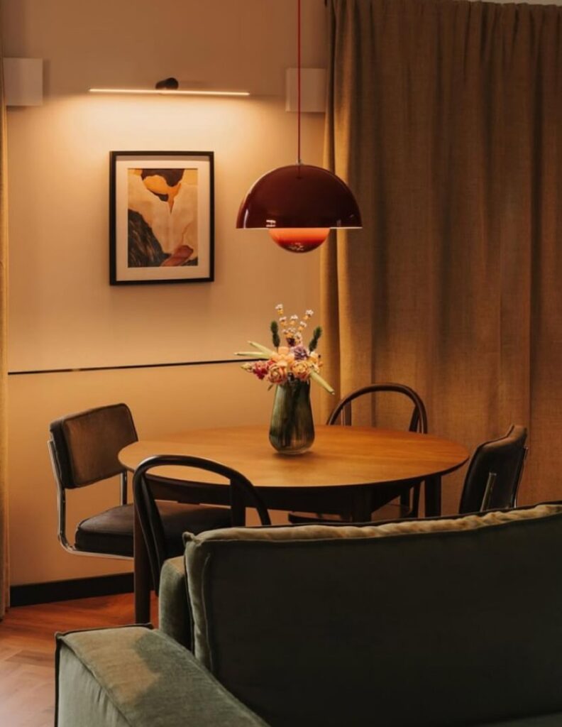 Sala de jantar com mesa redonda, quatro cadeiras e um pendente acima