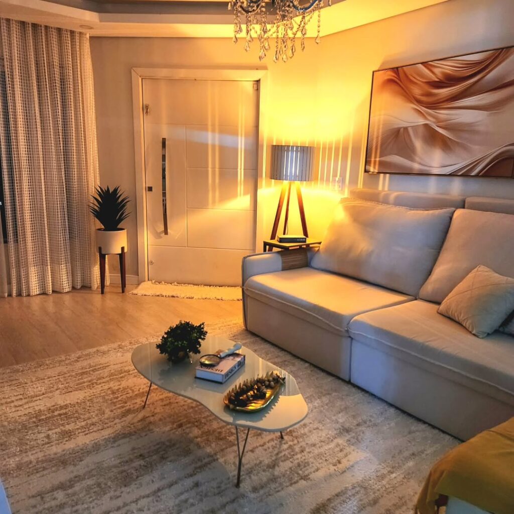 Sala em tons claros, com mesa de centro orgânica, sofá de linhas retas e luminária de piso