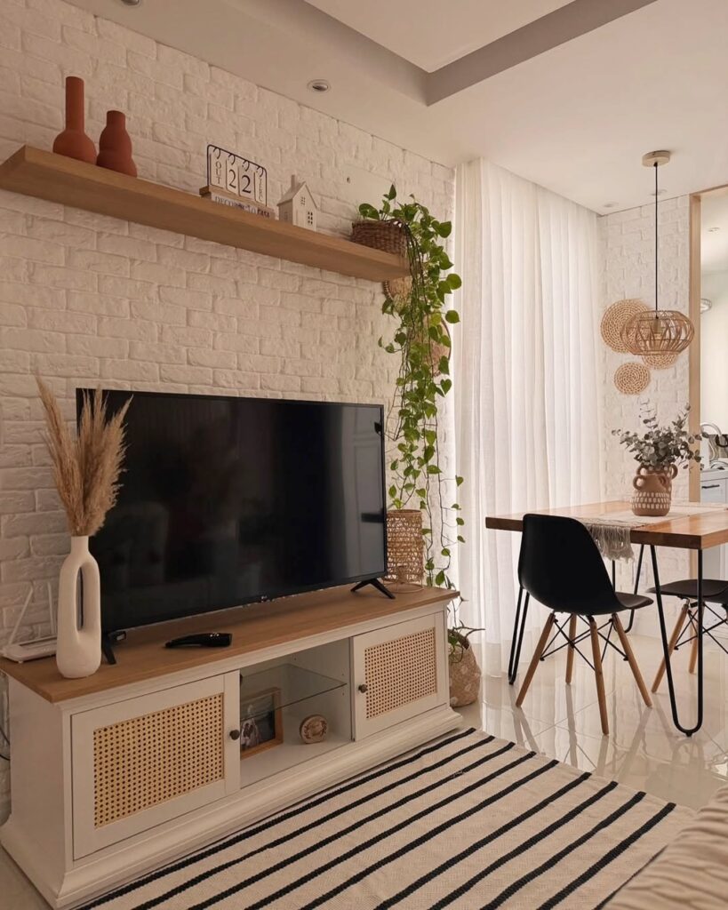 Sala de estar aconchegante com TV, rack, tapete e cortina branca