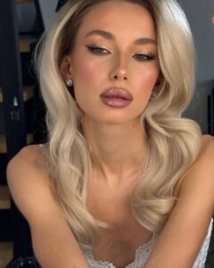 Mulher de pele clara, com cabelo loiro e maquiagem efeito lifting