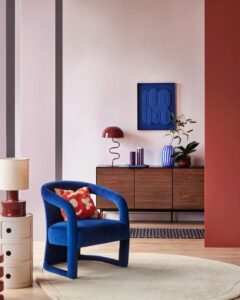 Sala de estar com poltrona na cor Luminous Blue com almofada em vermelho e branco