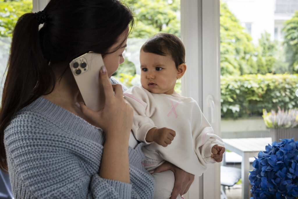 Mãe e bebê conversando no telefone