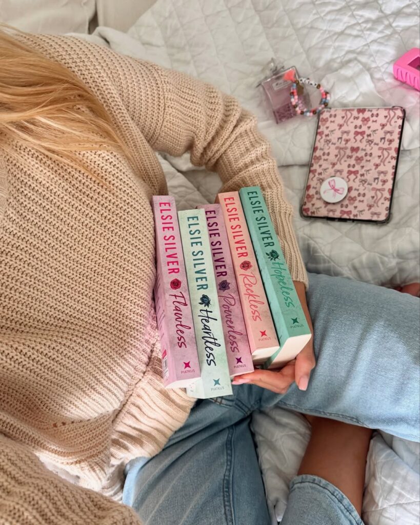 Mulher de pele clara, segurando os livros da série Chestnut Springs