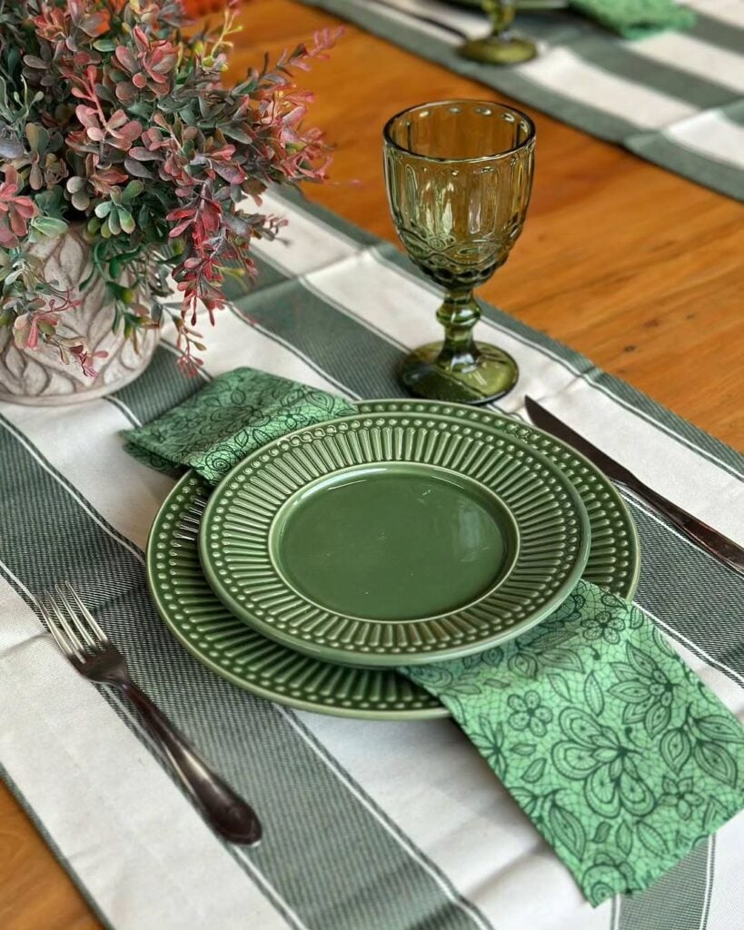 Mesa posta com pratos, taça e guardanapos verde
