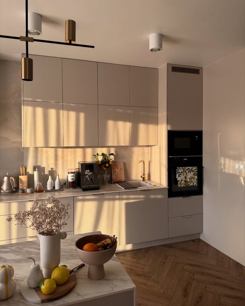 Cozinha em tons claros com eletrodomésticos embutidos