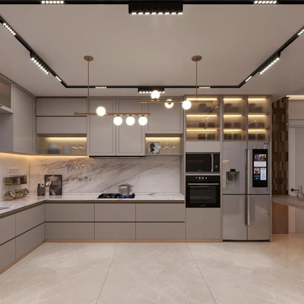 Cozinha em L em tons claros, com eletrodomésticos embutidos, iluminação com spots e pendentes