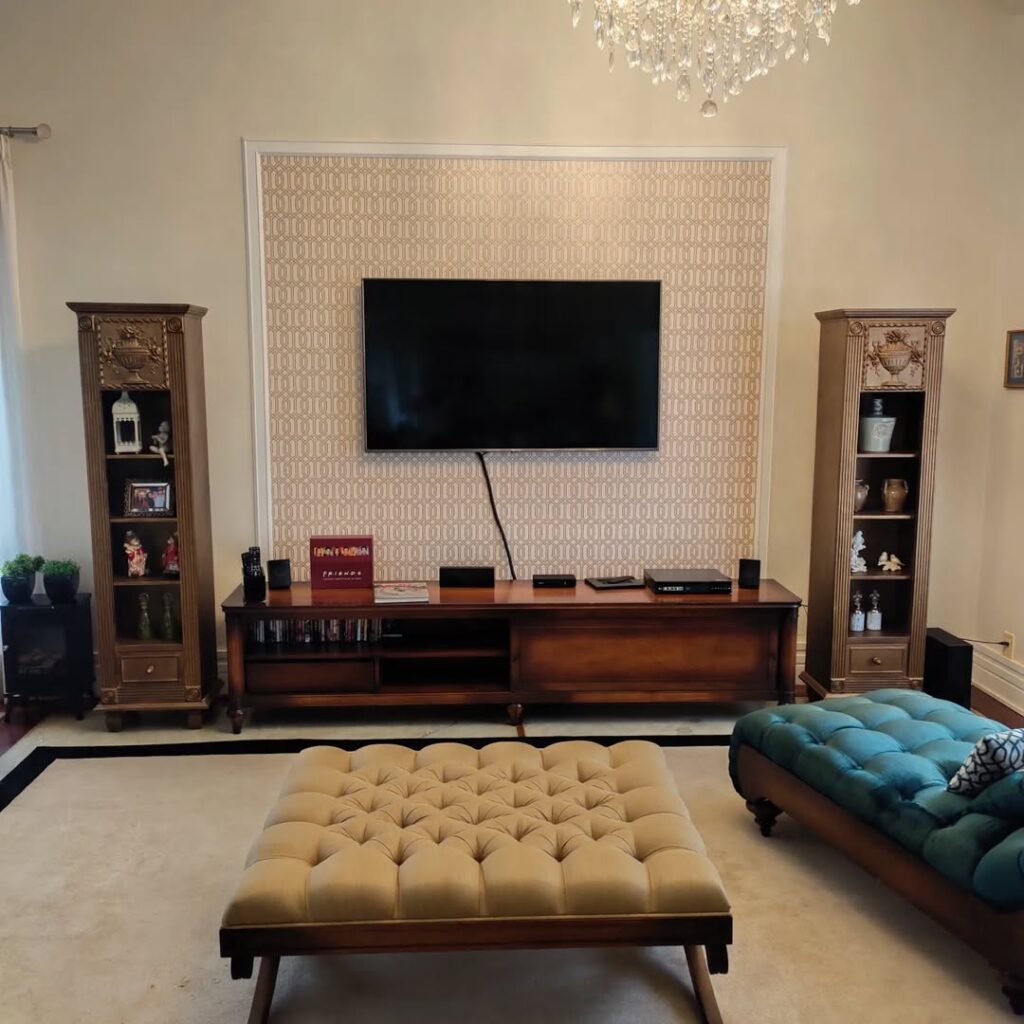 Sala de estar com rack de madeira e painel com papel de parede para a TV