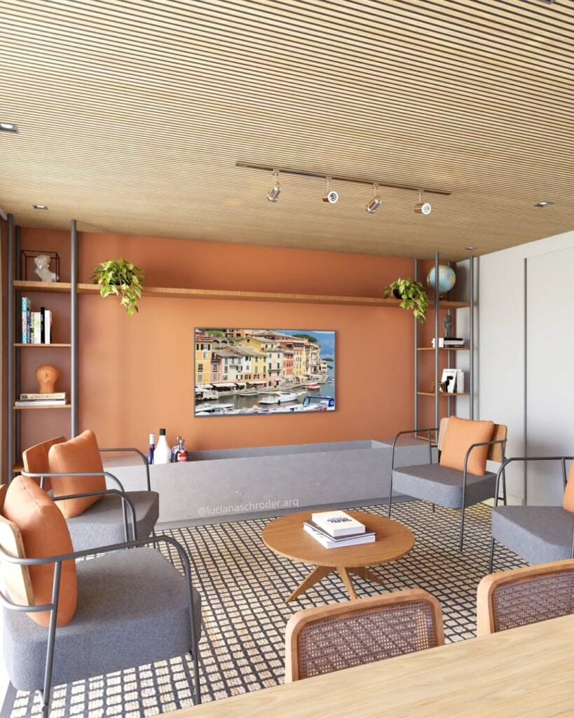 Sala de estar com parede em tom de terracota com poltronas de metal cinza, assento cinza e almofadas coloridas