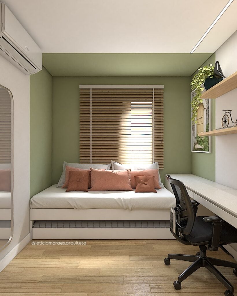 Quarto de hóspede com home office e parede verde, com sofá cama e mesa de trabalho ou estudos