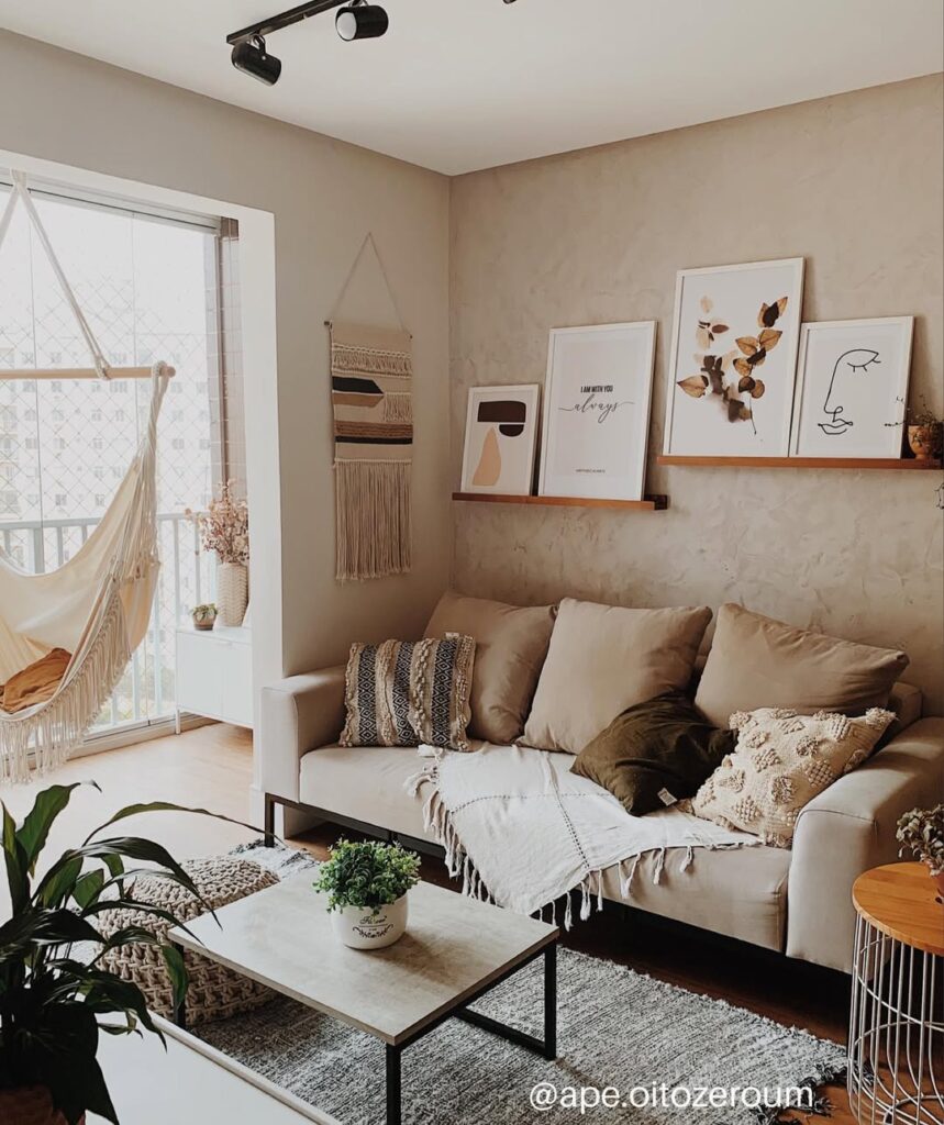 Sala de estar com almofadas e prateleiras com quadros