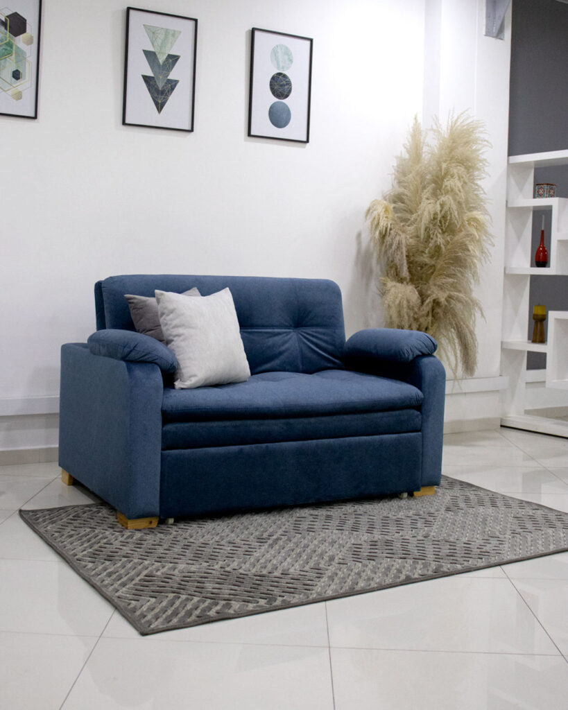 Sofá-cama de veludo azul com almofadas claras