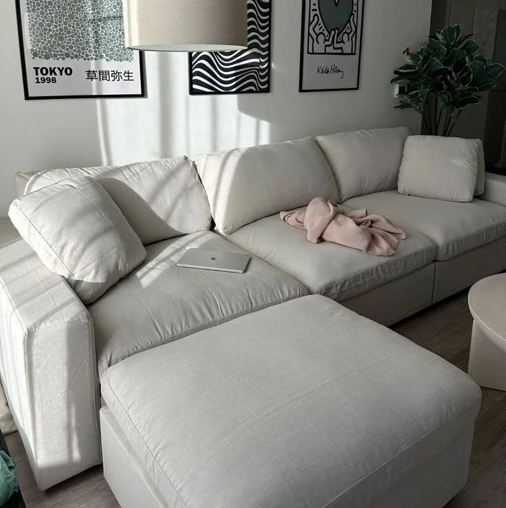 Sofá modular branco e quadros na parede
