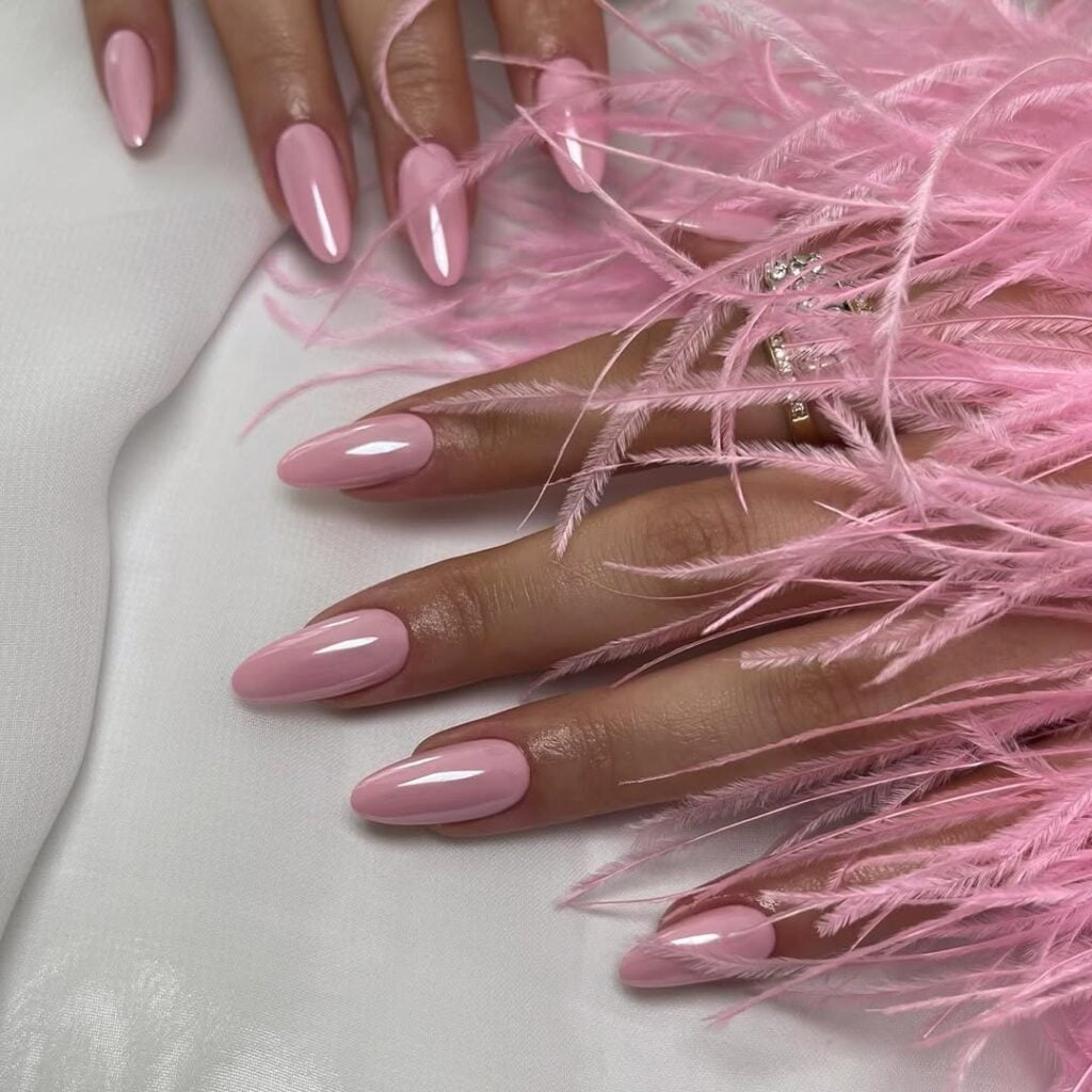 Mãos de pele clara, com unha amendoada rosa-claro