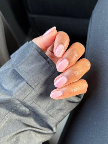 Mão de pele preta, com unha amendoada nude rosado