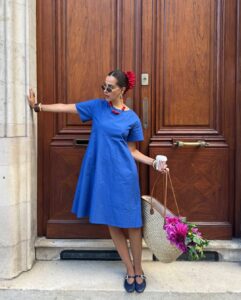 mulher jovem com vestido azul e acessório de cabelo vermelho
