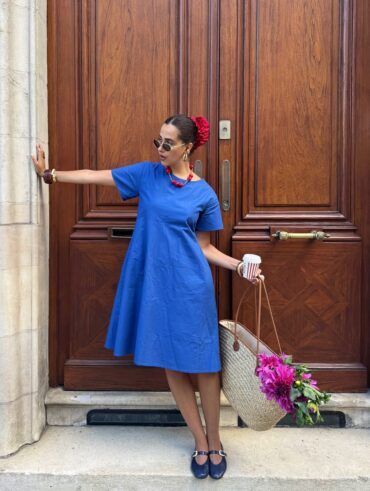 mulher jovem com vestido azul e acessório de cabelo vermelho