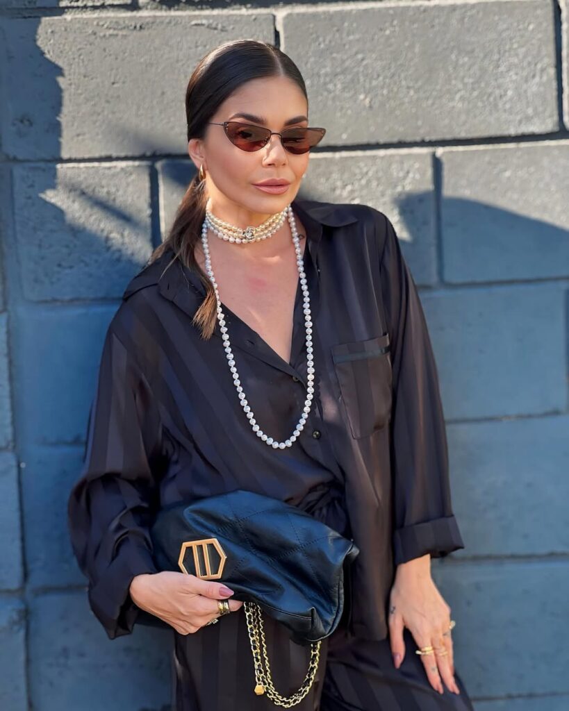 Mulher jovem com look com colar de pérolas alongado