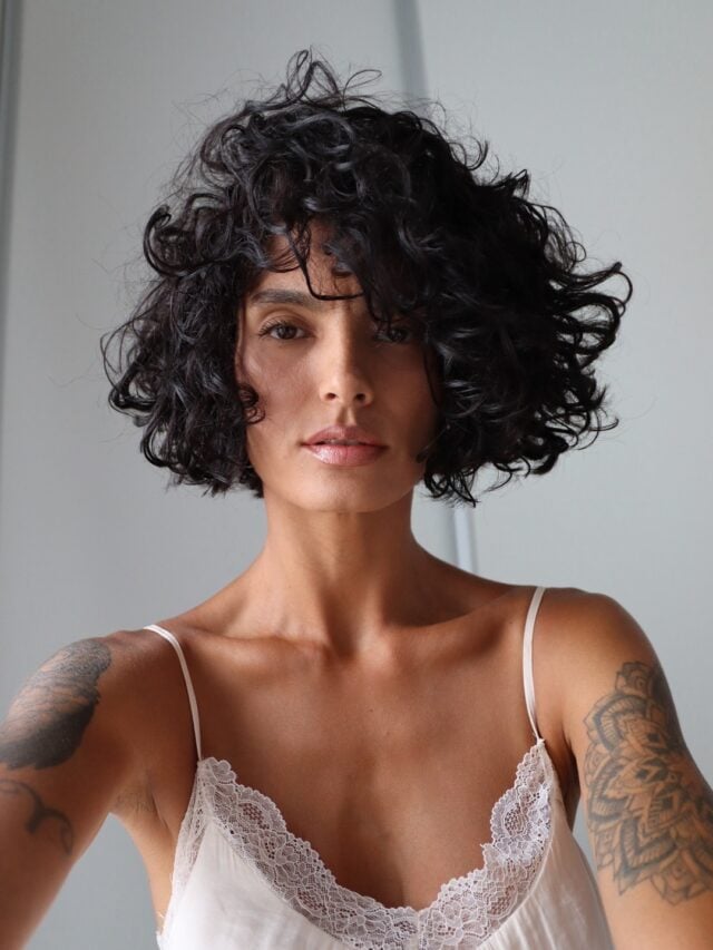Mulher branca com cabelo cacheado e corte chanel ou bob