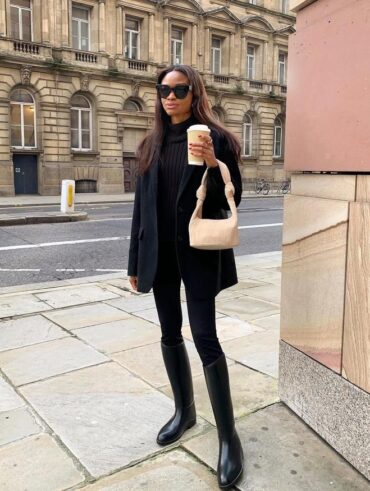 mulher jovem com calça legging com bota de cano longo, blazer e blusão de lã