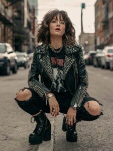 Mulher jovem e magra com pele clara e roupas pretas em estilo rock