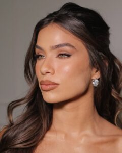 Mulher de pele clara, com cabelo castanho e maquiagem clean