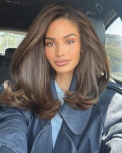 Mulher de pele clara, com jaqueta e cabelo castanho