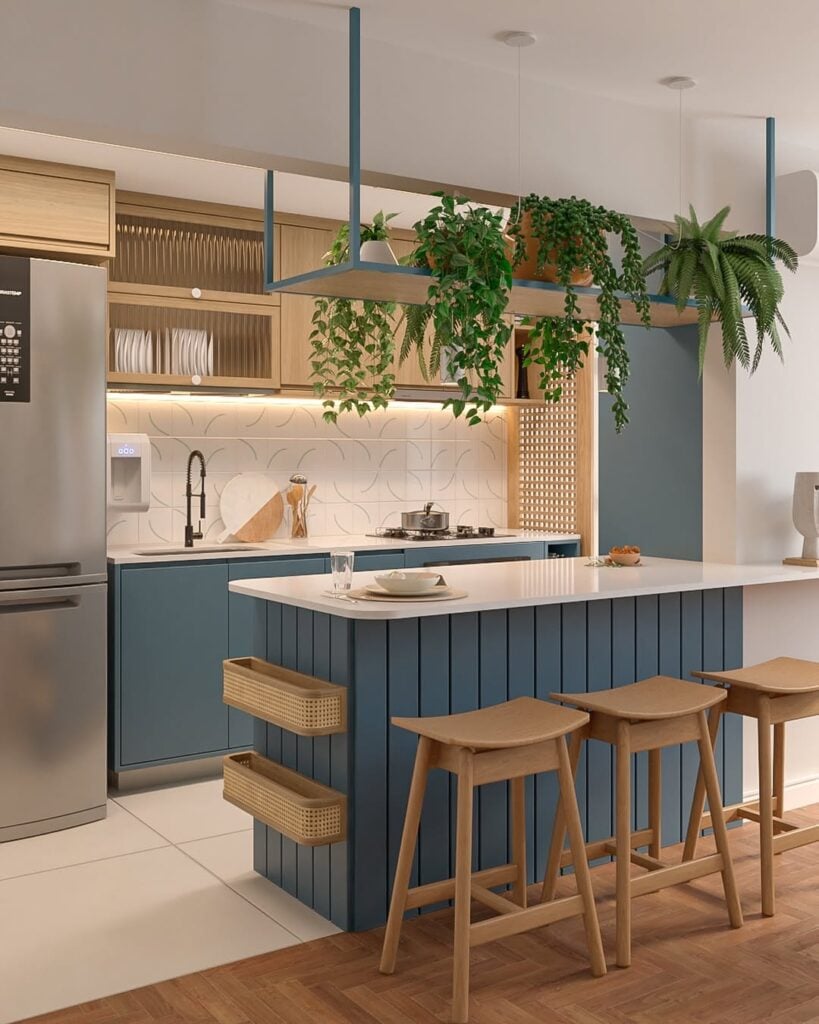 Cozinha com península e armário azul e na cor natural da madeira, e prateleira com plantas