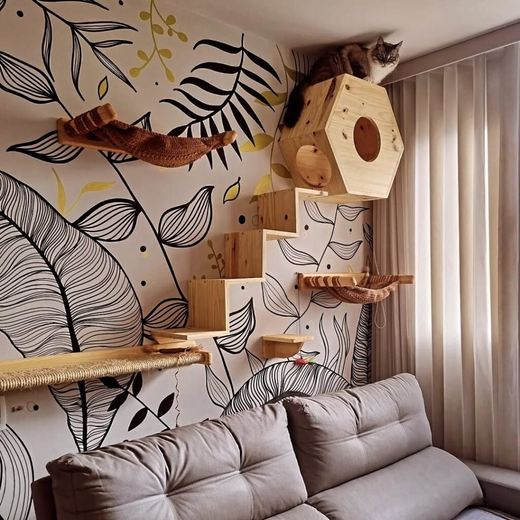 Sala de estar com papel de parede em branco, preto e amarelo, escada e nicho em madeira para gatos
