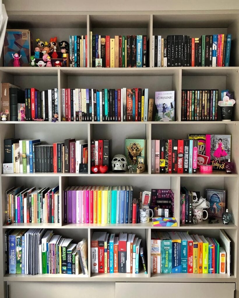 Estante branca com nichos, livros e objetos decorativos