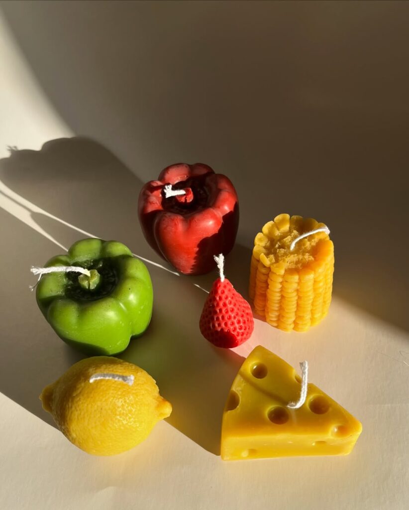 Velas decorativas em formato de pimentões, milho, limão, morang e queijo