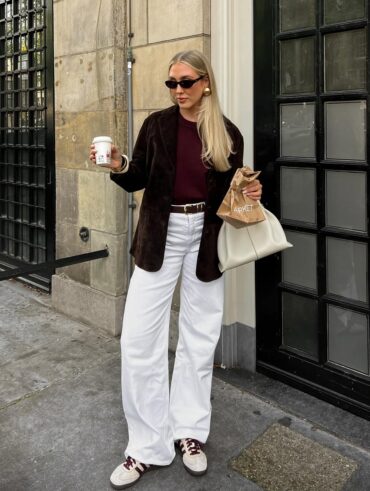 mulher jovem com look com jeans branco, tênis e casaco