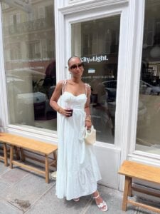 Mulher jovem e magra com pele ngra e vestido longo branco
