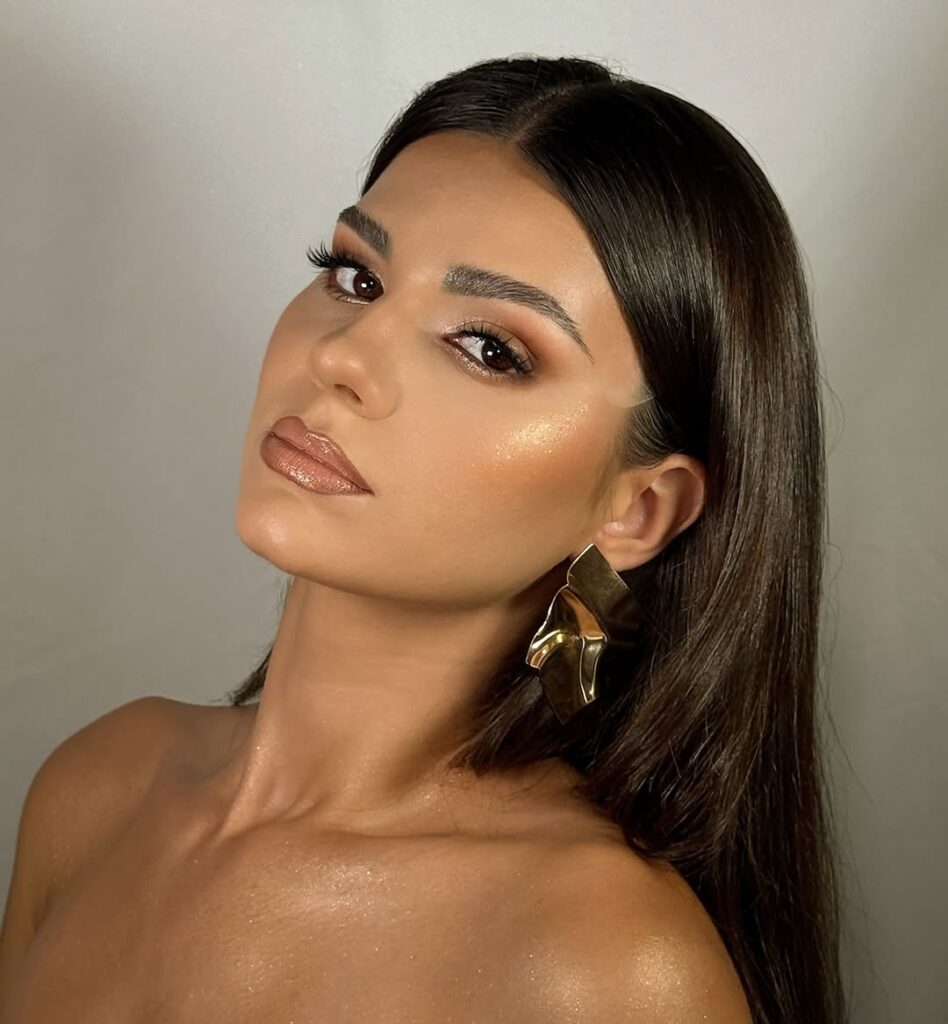 Mulher de pele clara, com cabelo escuro e make glow 