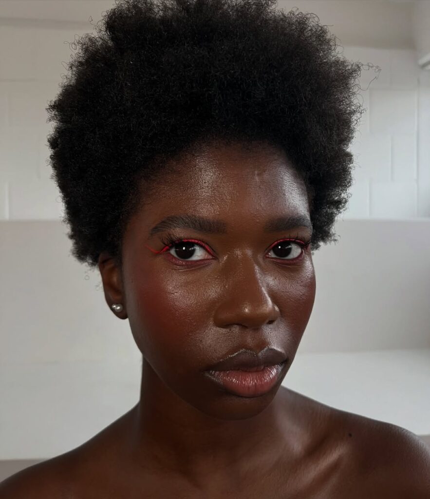 Mulher de pele preta, com cabelo crespo e pele glow 