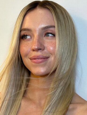 Sidney Sweeney, com cabelo loiro e maquiagem com sardas
