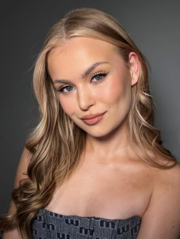 Mulher de pele clara, com tomara que caia, cabelo loiro e maquiagem glow