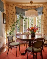 Sala de jantar com mesa redonda de madeira, papel de parede amarelo floral