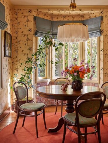Sala de jantar com mesa redonda de madeira, papel de parede amarelo floral