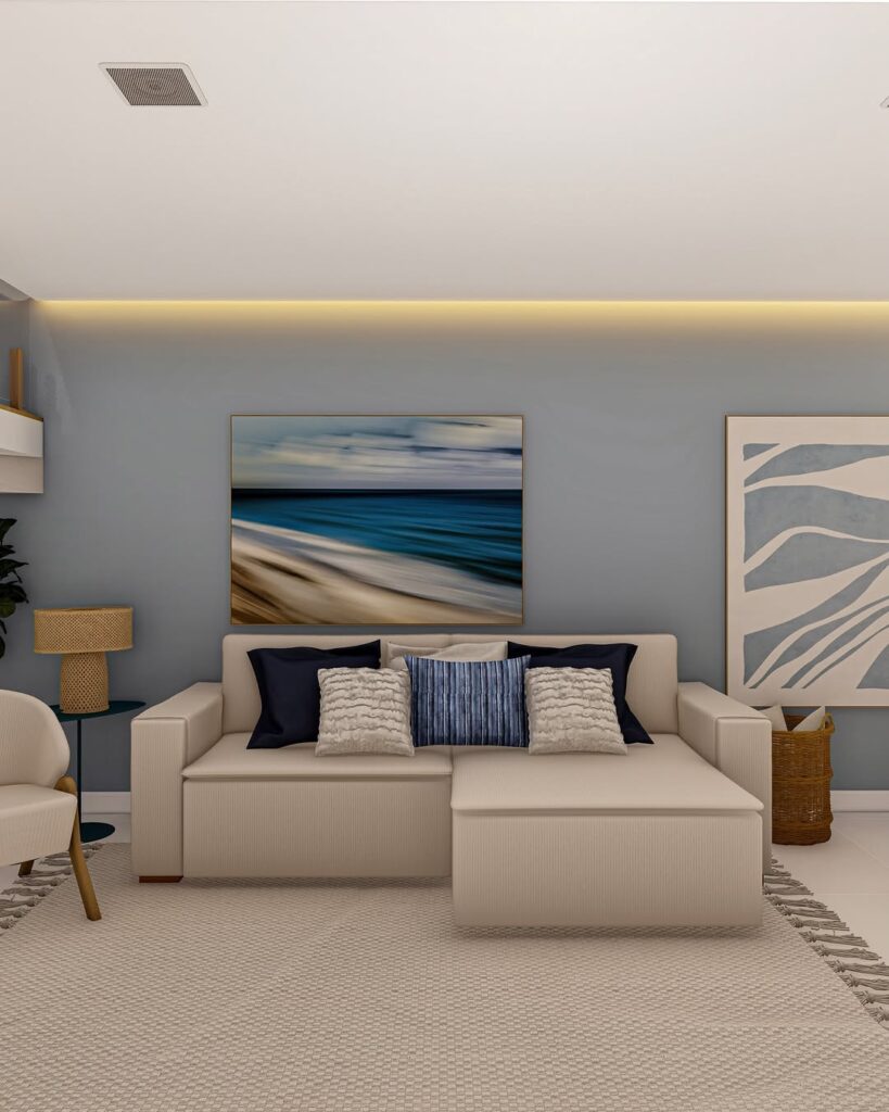 Sala com parede azul-claro e quadros, sofá bege com linhas retas e almofadas azuis