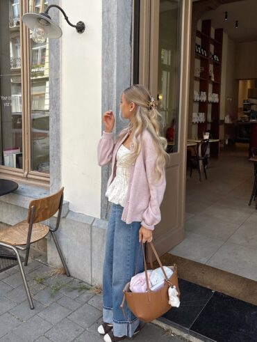 Mulher de pele clara, com blusa de poá, jeans e cabelo loiro